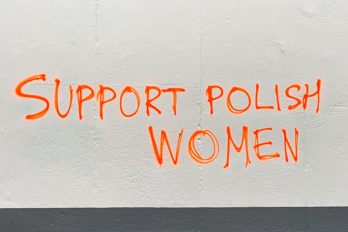 A sign that says support polish women on a wall