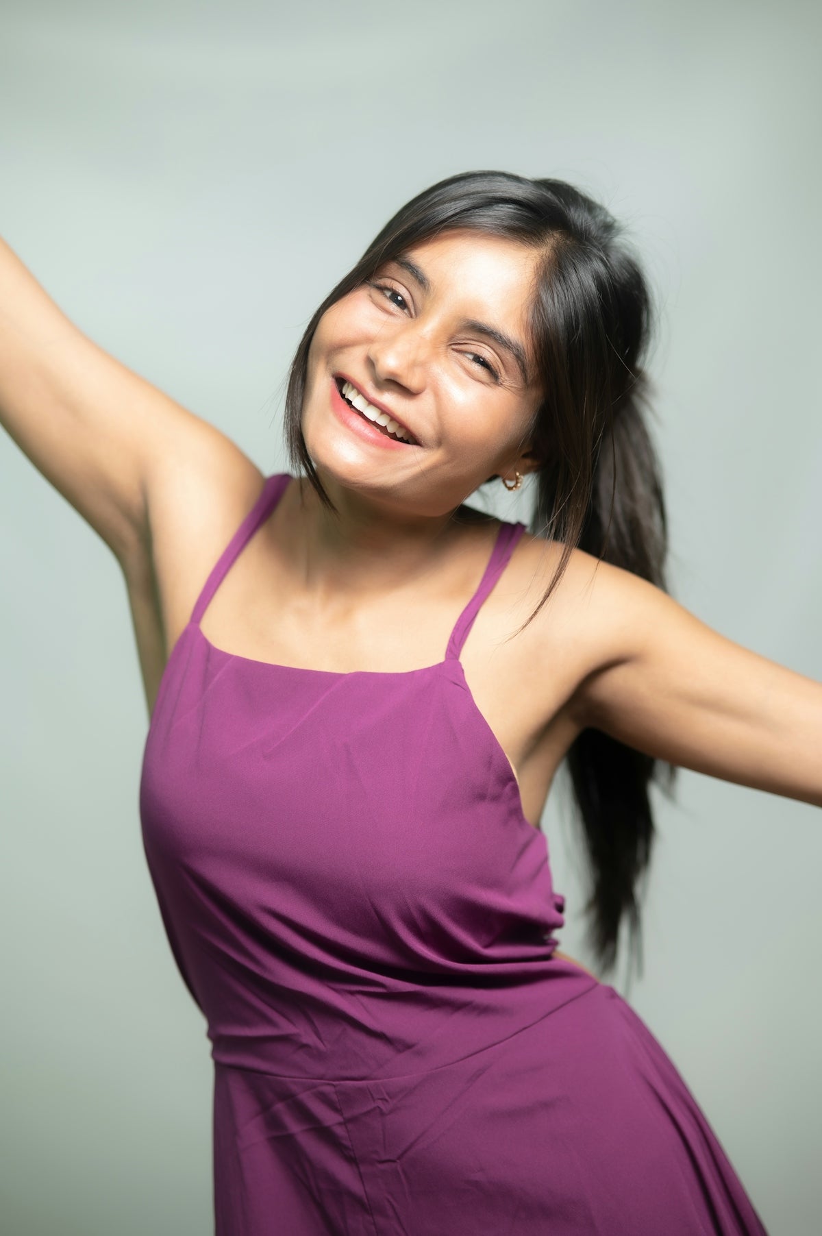 Happy woman in a purple dress smiles.