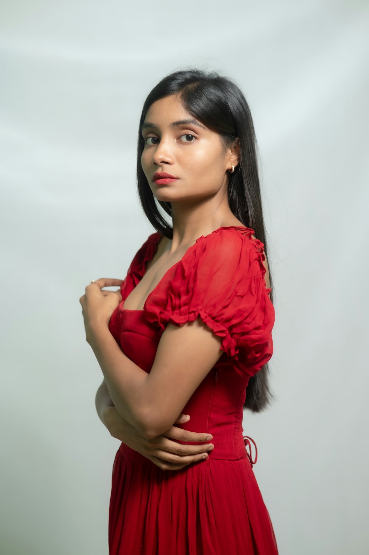 Woman in red dress poses for a photo.